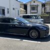 駐車場に停めた黒いレクサスLS500h version Lの右側面とロングボディ